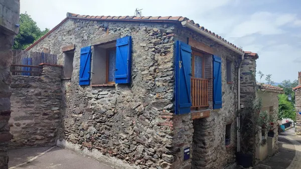 A barn in a peaceful setting between sea and mountains
